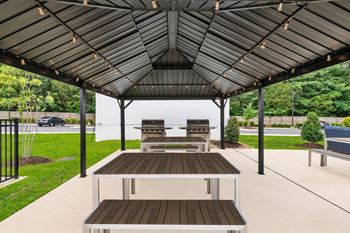 A covered patio with a table and chairs.